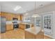 Bright kitchen featuring stainless steel appliances, wood cabinets, and island with light countertops at 125 Hidden Springs Dr, Durham, NC 27703