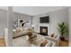 Staged living room featuring fireplace, hardwood floors, and large windows at 125 Hidden Springs Dr, Durham, NC 27703