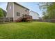 Expansive backyard showcasing the home's exterior, a deck, and lush greenery at 136 Ashlyn Ridge Dr, Garner, NC 27529