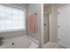 A secondary bathroom shows a bathtub, a glass enclosed shower, and a window at 136 Ashlyn Ridge Dr, Garner, NC 27529