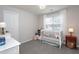 Bright bedroom features a large window, a white crib, and cozy decor at 136 Ashlyn Ridge Dr, Garner, NC 27529