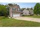 Two-story home with siding, two-car garage, and long concrete driveway in a suburban setting at 136 Ashlyn Ridge Dr, Garner, NC 27529