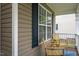 Inviting front porch with two wicker chairs, a small table, and a blue rug at 136 Ashlyn Ridge Dr, Garner, NC 27529