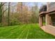 Expansive backyard with a gentle slope and bordered by trees and a glimpse of a covered deck at 144 Arabella Ct, Cary, NC 27518