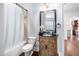 Well-lit bathroom with a vanity with drawers, a decorative mirror, and a shower-tub combination at 144 Arabella Ct, Cary, NC 27518