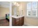 Bathroom featuring a wooden vanity with marble countertop and modern fixtures and a view into the bedroom at 144 Arabella Ct, Cary, NC 27518