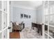 Stylish home office with French doors, a wood desk, and a comfortable patterned chair at 144 Arabella Ct, Cary, NC 27518