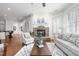 Open-concept living room featuring a stone fireplace and natural light at 144 Arabella Ct, Cary, NC 27518