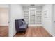 Sitting area featuring hardwood floors, a tufted bench, and built in bookshelves at 144 Arabella Ct, Cary, NC 27518