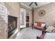 Cozy sunroom featuring a brick fireplace, comfortable seating, and tiled floors at 144 Arabella Ct, Cary, NC 27518
