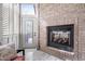 Sunroom showcasing a brick fireplace, glass doors, and cozy seating at 144 Arabella Ct, Cary, NC 27518