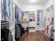 Spacious walk-in closet with custom shelving, hardwood floors and a view to the bathroom at 144 Arabella Ct, Cary, NC 27518