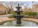 Elegant three-tiered water fountain creates a focal point amidst lush greenery and charming homes at 144 Arabella Ct, Cary, NC 27518
