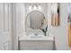 Stylish half bathroom featuring a modern vanity with a round mirror and updated light fixture at 1620 Briarmont Ct, Raleigh, NC 27610