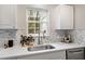 Bright kitchen with stainless appliances, marble countertop and backsplash, plus view to backyard at 1620 Briarmont Ct, Raleigh, NC 27610