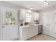 Charming kitchen features white cabinets, tile backsplash, stainless steel dishwasher, and a door to the outside at 1620 Briarmont Ct, Raleigh, NC 27610