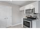 Bright kitchen features stainless steel appliances, white cabinets, and a stylish tile backsplash at 1620 Briarmont Ct, Raleigh, NC 27610