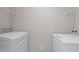 Bright laundry room featuring white appliances and convenient overhead shelving for storage and organization at 1620 Briarmont Ct, Raleigh, NC 27610