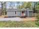 Charming home with gray siding, red door, gravel driveway, and landscaped front yard at 206 Woods Run, Knightdale, NC 27545