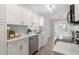 Well-lit kitchen with white cabinets, stainless steel appliances, and a view to the outdoor deck at 206 Woods Run, Knightdale, NC 27545