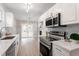 Modern kitchen with stainless steel appliances, white cabinets, and view into adjacent living room and fireplace at 206 Woods Run, Knightdale, NC 27545
