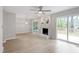 Bright living room featuring light wood floors, a painted brick fireplace, and access to the deck at 206 Woods Run, Knightdale, NC 27545