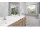 Bathroom with double sinks, marble floors, large mirror, and a window providing natural light at 2061 Carriage Way, Chapel Hill, NC 27517