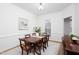 Elegant dining room featuring a wood table, wainscoting, framed art, and a bright window at 2061 Carriage Way, Chapel Hill, NC 27517