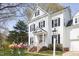 Charming two-story home with black shutters, beautiful lawn, decorative hanging flower baskets, and inviting entryway at 2061 Carriage Way, Chapel Hill, NC 27517