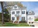 Charming white two-story home with black shutters, brick walkway, manicured lawn, and flower decor at 2061 Carriage Way, Chapel Hill, NC 27517