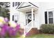 Inviting front porch with brick steps, white railings, and a glass front door at 2061 at 2061 Carriage Way, Chapel Hill, NC 27517