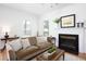 Comfortable living room with fireplace, sofa, side table, and bright windows with natural light at 2061 Carriage Way, Chapel Hill, NC 27517