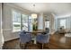 Cozy dining area features a round table, four chairs, a pendant light, and view to the yard at 2075 Toad Hollow Trl, Apex, NC 27502