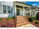 Inviting front porch with brick steps, black railings, and colorful landscaping at 2075 Toad Hollow Trl, Apex, NC 27502