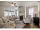 Bright living room with a fireplace, ceiling fan, large windows, and comfortable seating at 2075 Toad Hollow Trl, Apex, NC 27502