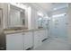 Bright bathroom with white cabinets, granite countertops, double sinks and a tiled glass enclosed shower at 2075 Toad Hollow Trl, Apex, NC 27502