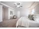 Spacious main bedroom featuring a ceiling fan, sitting area and a large bed with white patterned bedding at 2075 Toad Hollow Trl, Apex, NC 27502