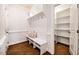 Organized mudroom with bench seating, cubbies, hooks, and a walk-in closet at 2075 Toad Hollow Trl, Apex, NC 27502