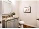 Stylish powder room with granite countertop, framed mirror, and decorative wall art at 2075 Toad Hollow Trl, Apex, NC 27502