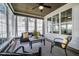 Inviting sunroom featuring many windows and comfortable seating arrangement with ceiling fan at 2075 Toad Hollow Trl, Apex, NC 27502
