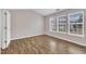Empty bedroom showcasing wood-look floors, neutral paint, and three large windows at 208 Chandler Chase Ct, Morrisville, NC 27560