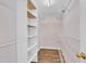 Walk-in closet with adjustable shelving units and wood-look floors at 208 Chandler Chase Ct, Morrisville, NC 27560