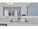 A well-lit kitchen sink with granite countertops with updated plumbing and blue accent wall at 208 Chandler Chase Ct, Morrisville, NC 27560