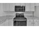 Modern kitchen featuring stainless steel appliances, white cabinetry, and granite countertops at 208 Chandler Chase Ct, Morrisville, NC 27560