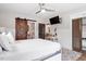 Bright bedroom featuring a barn door, ceiling fan, and white wainscoting at 208 S Guthrie Ave, Durham, NC 27703