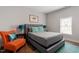 Inviting bedroom with hardwood floors, gray bed, and pops of color with accent chair at 208 S Guthrie Ave, Durham, NC 27703