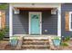 Close-up of the front door with its stylish, light blue color and stone steps at 208 S Guthrie Ave, Durham, NC 27703
