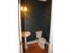 Small powder room with patterned wallpaper, wood floor, and pedestal sink at 218 Keith Hills Rd, Lillington, NC 27546