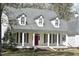 Inviting home with a welcoming porch supported by elegant columns and eye-catching dormer windows at 218 Keith Hills Rd, Lillington, NC 27546