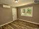 Cozy bedroom featuring hardwood floors, a door, and a bright window at 220 Barclay Rd, Chapel Hill, NC 27516